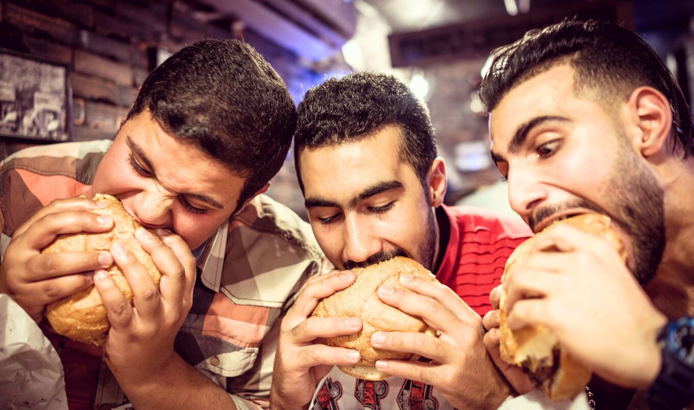 men eating burgers